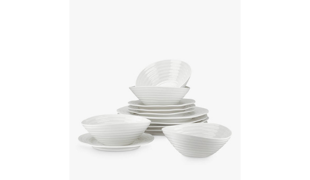 a stack of white porcelain dinner plates and bowls