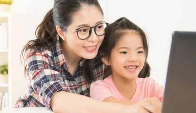 woman/mother helping child with task computer