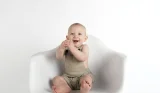 Baby boy sat on chair smiling