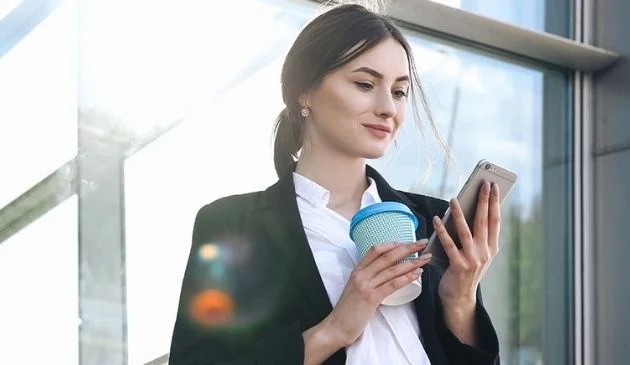 woman holding reusable coffee cup