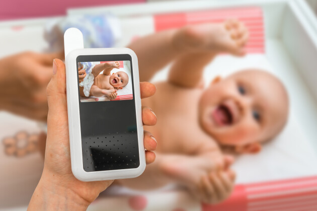 baby monitor with baby smiling in the background
