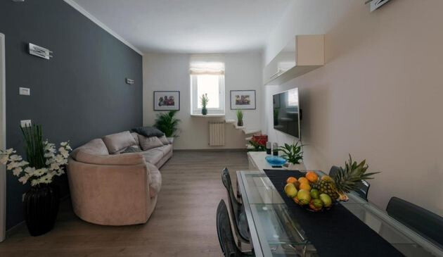 Apartment living area with sofa, TV and dining table