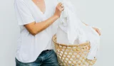 A woman in a white t-shirt with a laundry basket