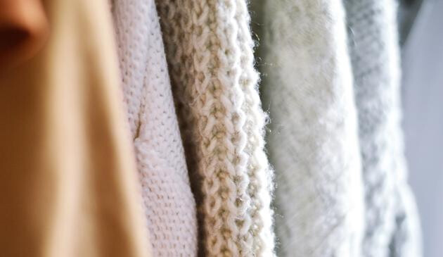 A close up picture of clothes on coat hangers.