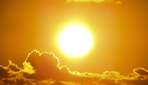 A picture of sun shining at sunset.