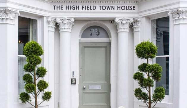 A picture of the front door and sign outside of the High Field Town House.