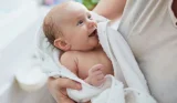 Woman holding baby in towel