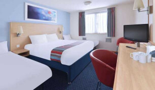 Beds, desk and a chair in a Travelodge room