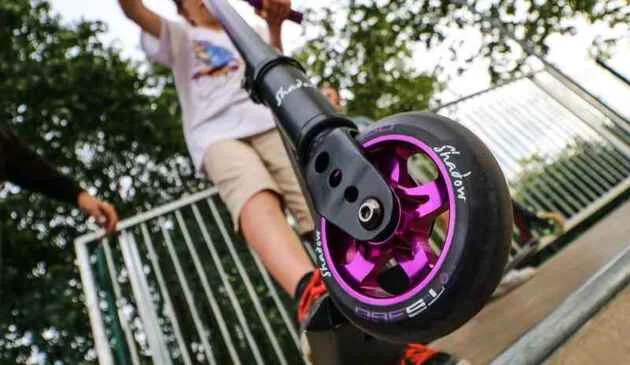 Close up shot of the shadow stunt scooter with a child riding on it