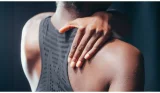 woman touching her upper back