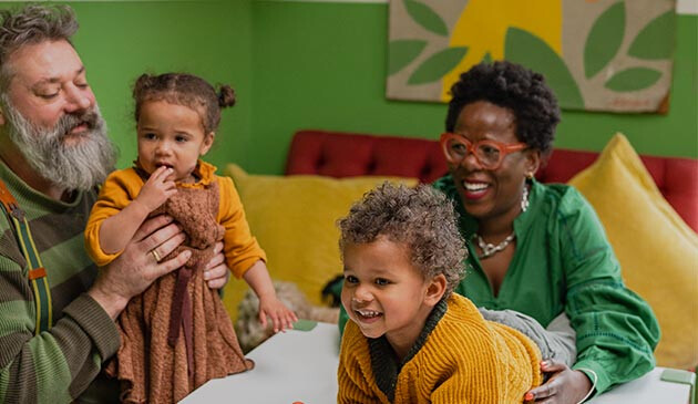 Family playing with grandchildren at home