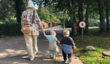 A mum and twin sons walking around Whitemead Forest Park