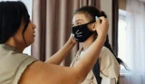 Mum helping child with a face mask